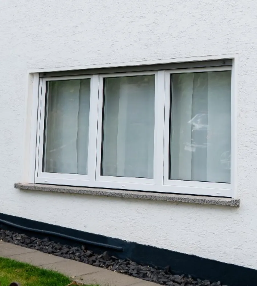 Dreiteiliges weißes Fenster in verputzter Fassade